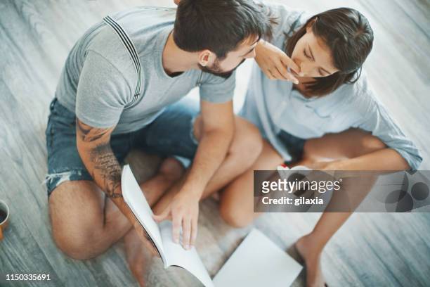 young couple looking at decoration brochures. - moments daily life from above imagens e fotografias de stock