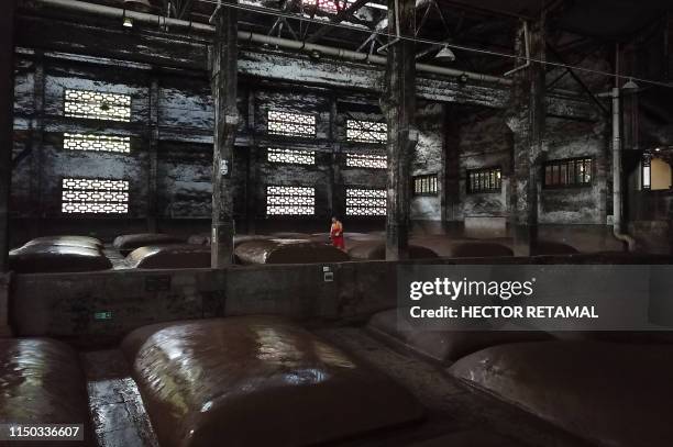 In this photo taken on April 24 a worker moistens mounds where grain is fermented at the Luzhou Laojiao distillery where baijiu is produced in...