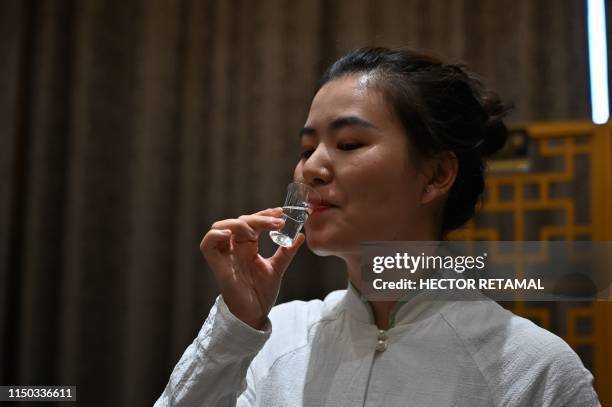 In this photo taken on April 22 an employee from a baijiu distillery performs a tasting in Luzhou, southwestern China's Sichuan province. - Baijiu's...