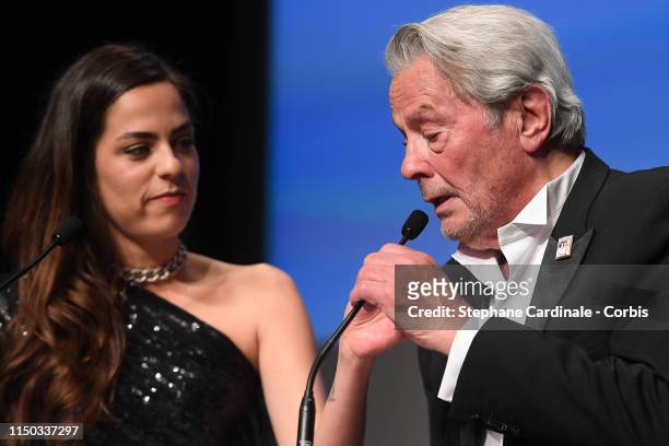 Alain Delon speaks alongside his daughter Anouchka Delon during the Ceremony for Palme Honneur during the 72nd annual Cannes Film Festival on May 19,...