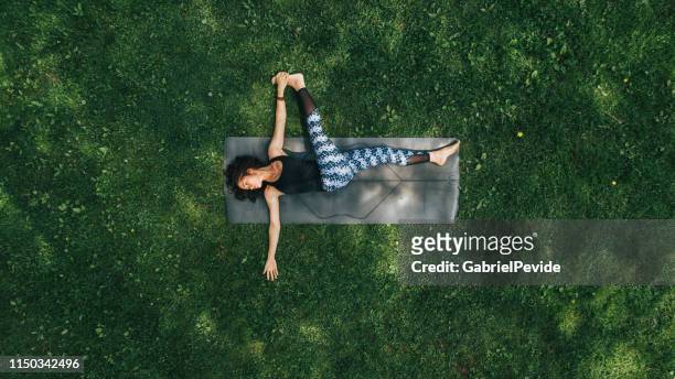 frau macht yoga im park - yoga stock-fotos und bilder