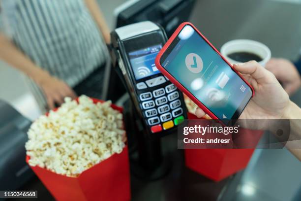 making a contactless payment at the concession stand at the cinema - concession stand stock pictures, royalty-free photos & images