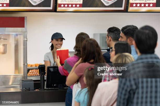 mujer feliz vendiendo comida en el puesto de concesión en el cine - puesto-de-comida-rápida fotografías e imágenes de stock