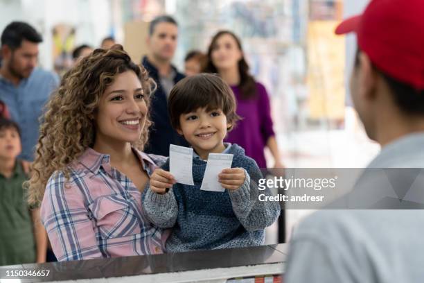 mother and son buying tickets at the movie theater - cinema ticket stock pictures, royalty-free photos & images