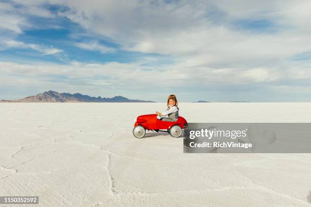 young business boy drives toy car - vintage racing driver stock pictures, royalty-free photos & images