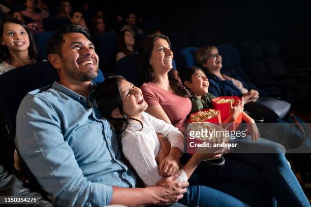 fröhliche familie schaut sich einen comedy-film im kino an - filmindustrie stock-fotos und bilder