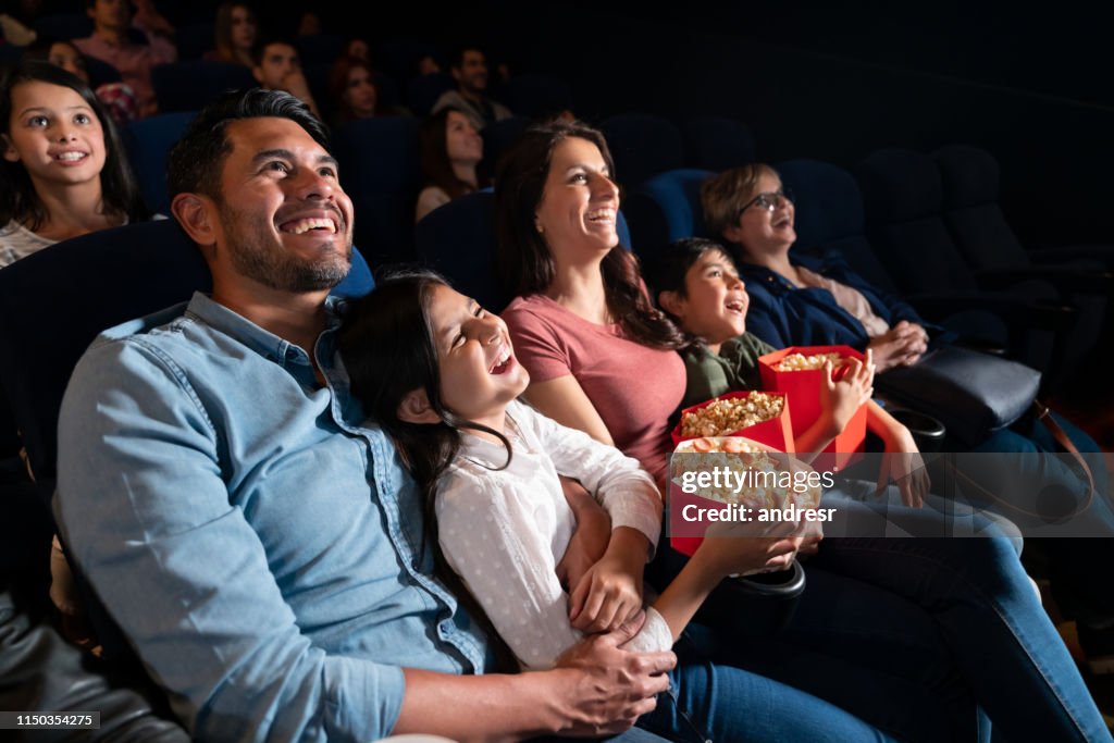 Happy family watching a comedy film at the cinema