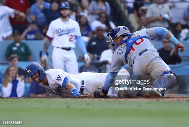 Chris Taylor of the Los Angeles Dodgers beats the tag by catcher Willson Contreras of the Chicago Cubs at home plate to score in the eighth inning of...