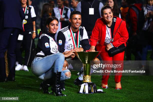 Cristiano ROnaldo of Juventus poses with the Serie A trophy alongside his girlfriend Georgina Rodríguez and mother Maria Dolores dos Santos Aveiro...