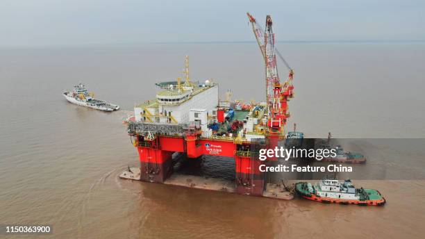 Tugboats move a semi-submersible platform of accommodations built by a COSCO shipyard to a sea-trial in Nantong in east China's Jiangsu province...