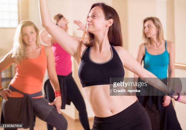 instructor de fitness y grupo de gente feliz bailando en el gimnasio - belly dancer fotografías e imágenes de stock