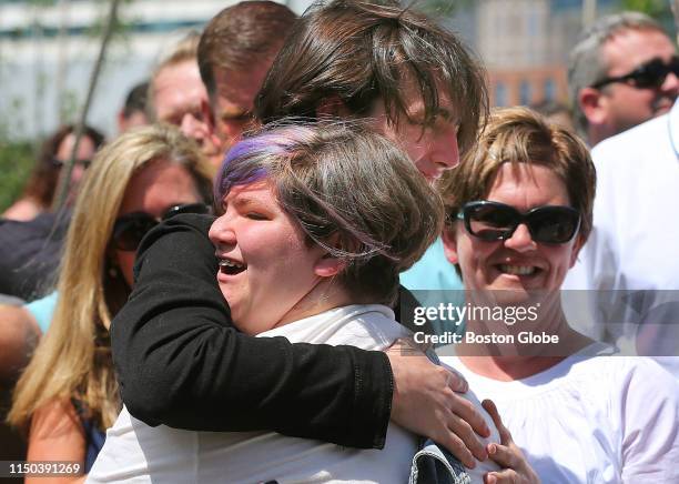 Jane Martin gets a hug from her brother, Henry, after she sang a song, as her mother Denise looks on during the opening of Martin's Park in Boston on...