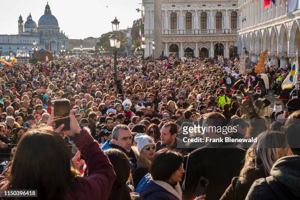 Thousands of people are gathering along the Grand Canal, Canal Grande to celebrate the Venetian Carnival, the Basilica of Saint Mary of Health,...