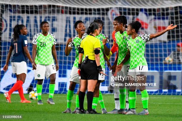 Nigeria's players react to Honduran referee Melissa Borjas after she ruled a French penalty be re-hit due to the goalkeeper moving off the goal line...