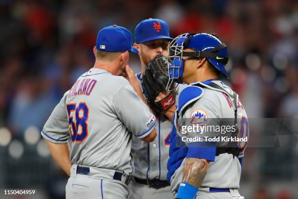 Zack Wheeler of the New York Mets speaks with Wilson Ramos and pitching coach Dave Eiland in the fifth inning of an MLB game against the Atlanta...