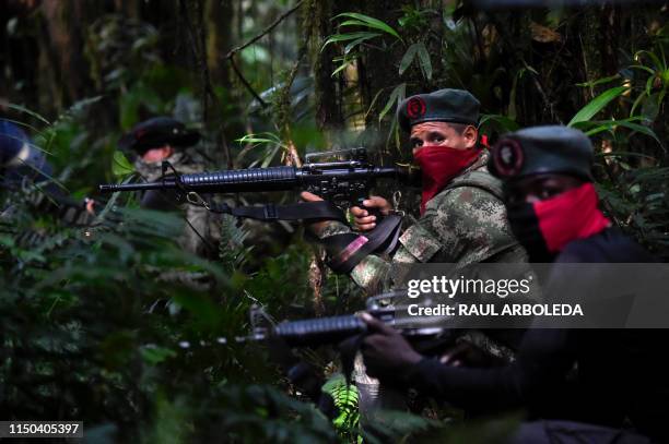 Members of the Ernesto Che Guevara front, belonging to the National Liberation Army guerrillas, shoot during a training in the jungle, in Choco...