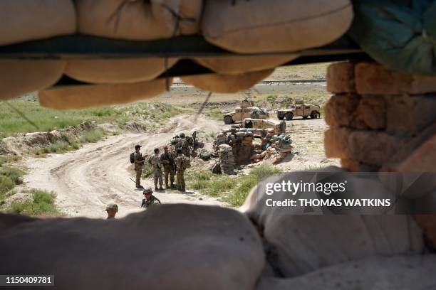In this photo taken on June 6 US troops are seen through a firing position at the Afghan National Army checkpoint in Nerkh district of Wardak...