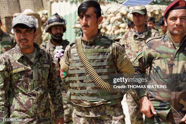 In this photo taken on June 6 Afghan National Army soldiers look on during a visit of commander of US and NATO forces in Afghanistan General Scott...