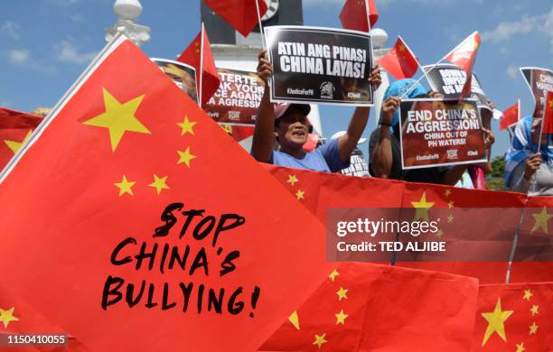 Activists display anti-China placards and flags during a protest at a park in Manila on June 18 after a Chinese vessel last week collided with a...