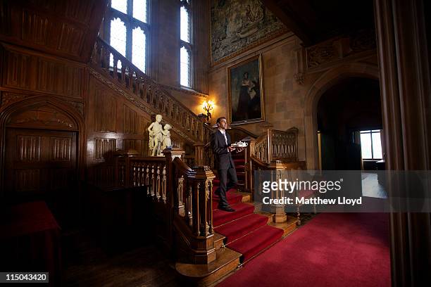 Luis Coelho, Banqueting Manager, serves tea on the oak staircase in Highclere Castle on March 15, 2011 in Newbury, England. Highclere Castle has been...