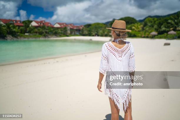 sunny tropical summer feelings woman walking on sand beach - white dress stock pictures, royalty-free photos & images