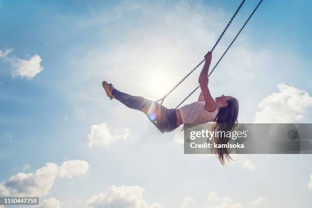 jonge volwassen vrouw zwaaien tegen blue sky - zwaaien stockfoto's en -beelden