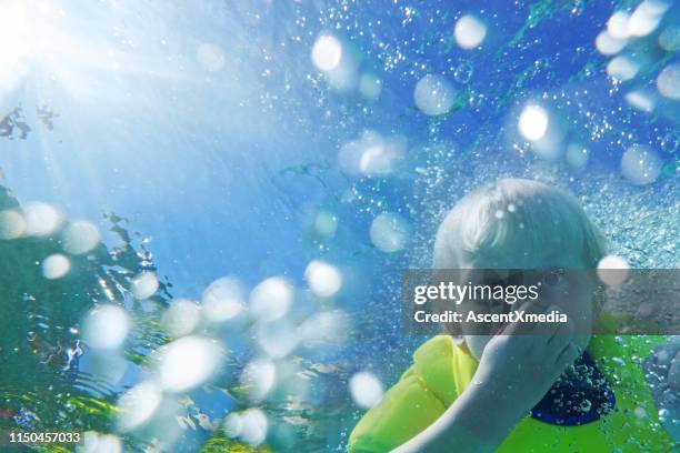 underwater perspective of baby in swimming pool - holding nose stock pictures, royalty-free photos & images