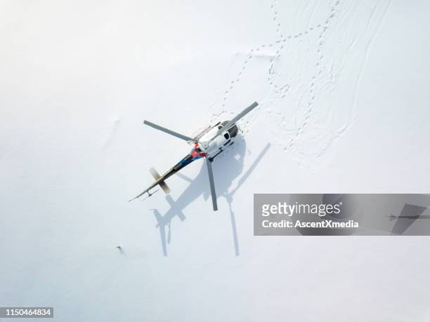 überkopfperspektive des hubschraubers auf einem schneebedeckten feld geparkt - hubschrauber landeplatz stock-fotos und bilder