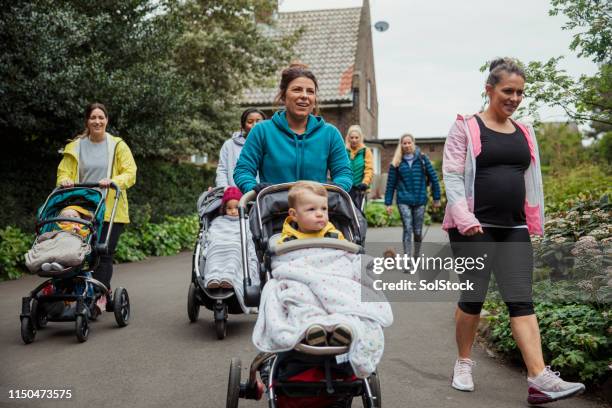 mothers exercising together - baby pram in the park stock pictures, royalty-free photos & images