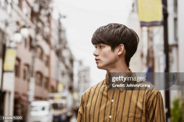 portrait of young japanese man wearing striped shirt - japanse man stock pictures, royalty-free photos & images