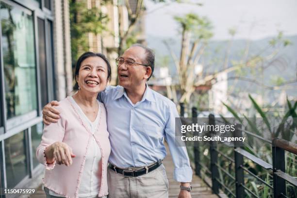 happy senior couple standing on balcony at home - asia stock pictures, royalty-free photos & images