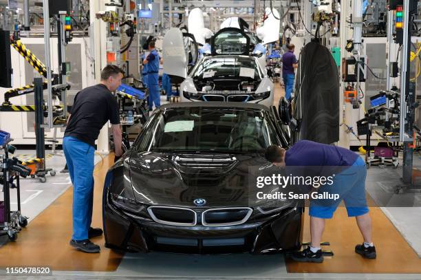 Workers assemble BMW I8 hybrid cars on the assembly line at the BMW factory on May 20, 2019 in Leipzig, Germany. German President Frank-Walter...