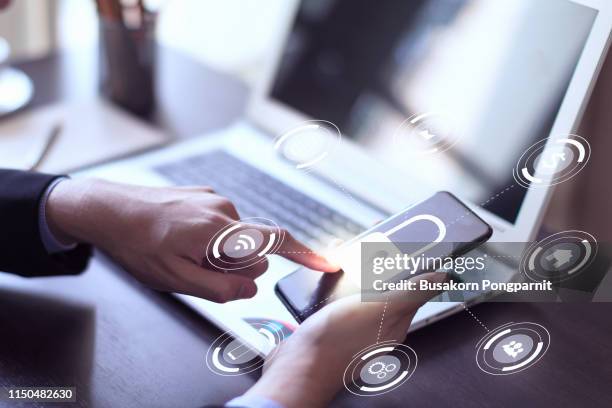 businessman hand working with mobile phone and laptop computer with technology digital graphic - interview icon stock-fotos und bilder