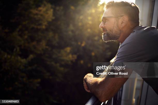 casual mature man on balcony having a break - time out stock pictures, royalty-free photos & images