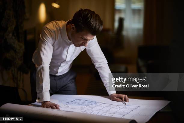 architect looking at floor plan on desk - 2018 blueprint stock-fotos und bilder