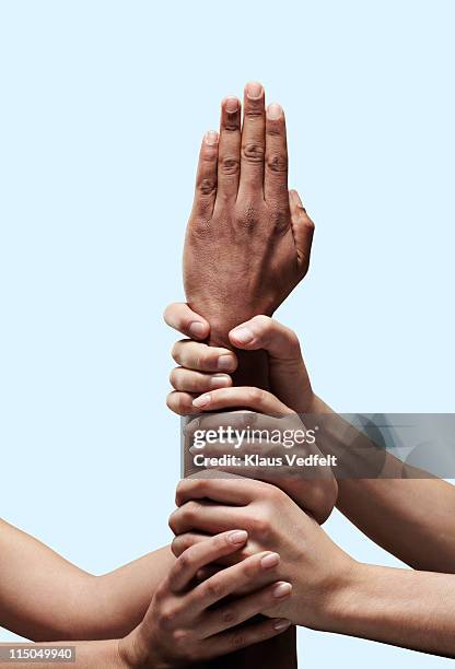 group of hands grabbing an arm with open hand - aferrarse fotografías e imágenes de stock