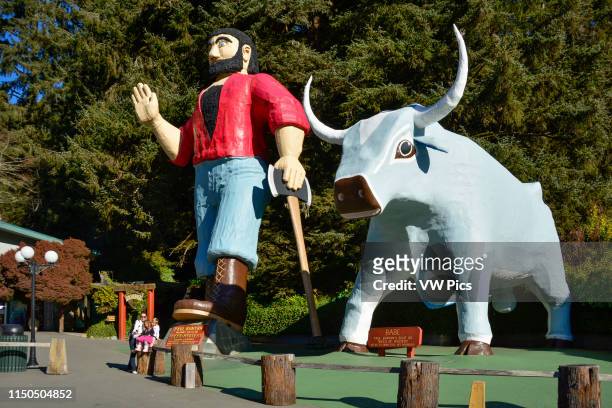 Family taking selfie with statues of Paul Bunyan and his ox Babe at Trees of Mystery in the Redwoods of northern California.
