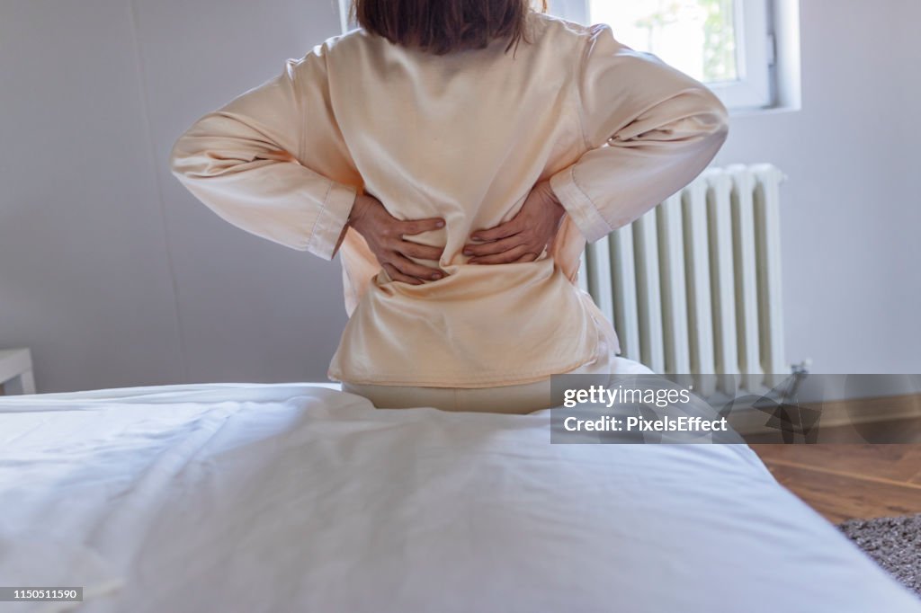 Woman feels back pain massaging aching muscles