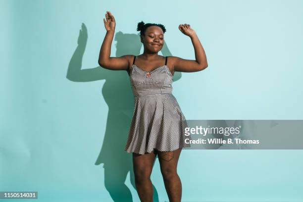 dancing black woman on turquoise background - heroic style stockfoto's en -beelden