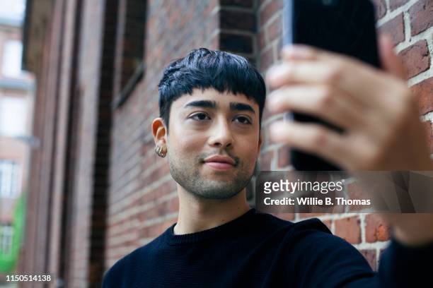 handsome gay man taking a selfie - androgynous stock-fotos und bilder