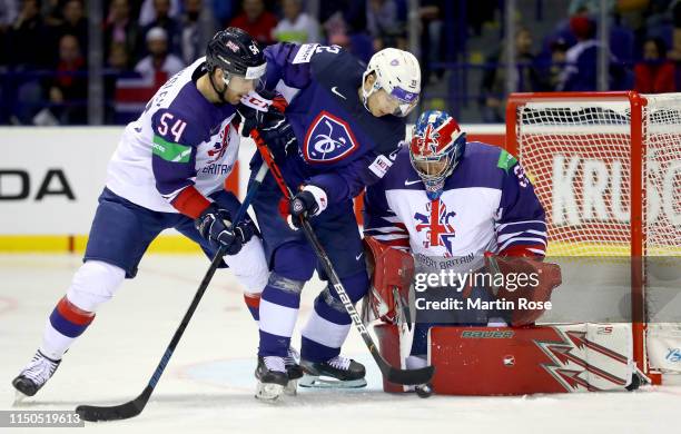 Guillaume Leclerc of France challenges Tim Billingsley and Ben Bowns, goaltender of Great Britain during the 2019 IIHF Ice Hockey World Championship...