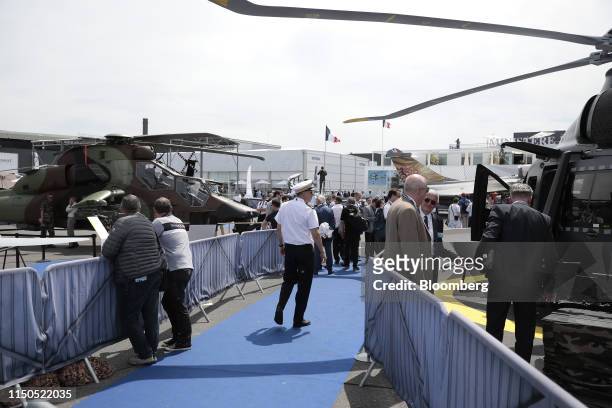Attendees inspect helicopters on display during the 53rd International Paris Air Show at Le Bourget in Paris, France, on Tuesday, June 18, 2019. The...