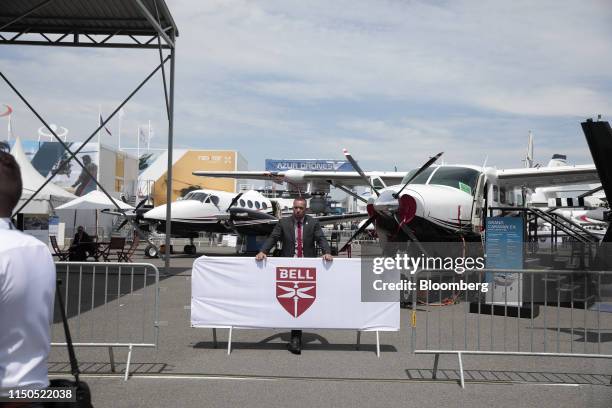 An employee movers a barrier fence on the Bell Helicopter Textron Inc. Exhibition stand during the 53rd International Paris Air Show at Le Bourget in...