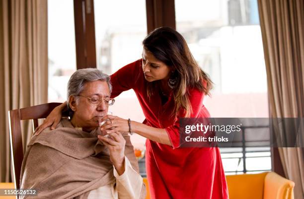 woman giving water to her ill father - caring stock pictures, royalty-free photos & images