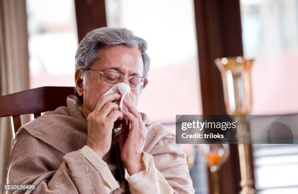 uomo anziano starnutisce - virus grippe foto e immagini stock