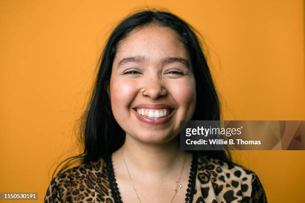 queer smiling hispanic woman on colorful background - portrait orange background stock pictures, royalty-free photos & images