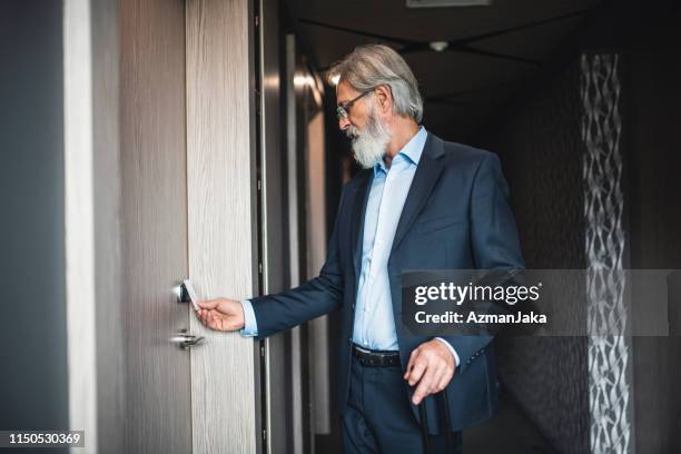 caucasian businessman using a keyless entry card to enter his hotel room - entry card stock pictures, royalty-free photos & images