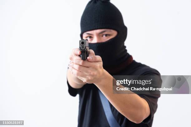 burglar or terrorist in black mask shooting with gun isolated on white background - hijack stock pictures, royalty-free photos & images