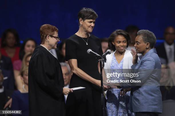 With her wife Amy Eshleman and daughter Vivian by her side Lori Lightfoot is sworn in as Mayor of Chicago by Judge Susan Cox during a ceremony at the...