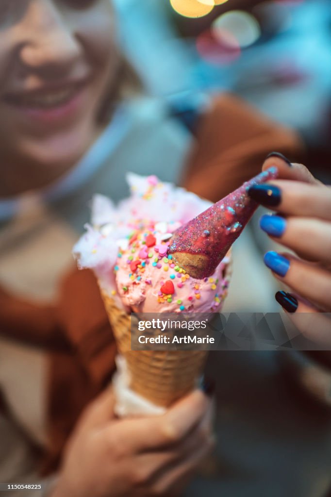 Chica adolescente sonriente con helado de fusión rosa al aire libre en verano